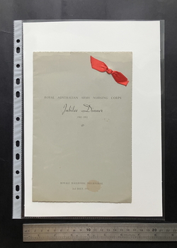 Grey folded card with deckled edges, black text and a red fabric ribbon tied through the card in the top right corner.