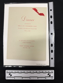 A pale grey folded card with red printed text and a red ribbon tied in the upper right hand corner