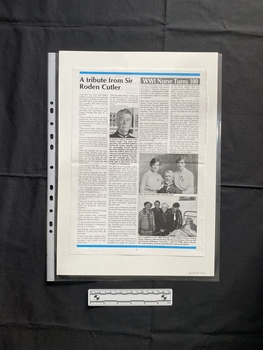 A magazine page with two vertical stories, the relevant story consists of two columns of text beneath the title, and two black and white photos