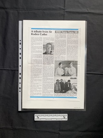 A magazine page with two vertical stories, the relevant story consists of two columns of text beneath the title, and two black and white photos