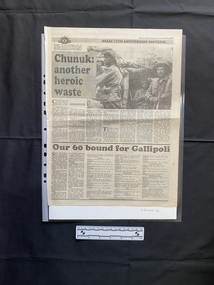 A large newspaper clipping that comprises of two stories with the top story having a black and white photo and seven columns of text and the bottom story having five columns of text