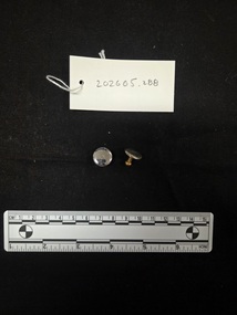 Two aluminium and brass cufflinks. The front face of the cufflinks is aluminium and the shank is brass.