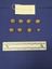 Eight brass buttons with a raised Royal Australian Air Force crown and eagle motif. All buttons are the same size with the exception of one smaller button.