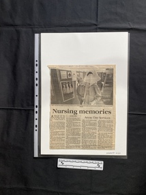  A newspaper clipping of a large black and white photo above the title and four columns of text.