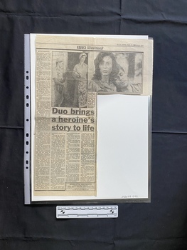 A newspaper clipping consisting of a title, four columns of text and two black and white photos
