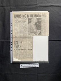 A large newspaper clipping consisting of two stories with titles and four columns of text each.  The larger story also has two black and white photos