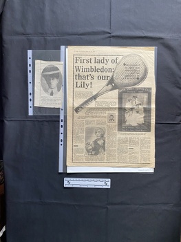Two newspaper clippings: The large clipping is a full page story with a large title, seven columns of text and three pictures. The small clipping is of a photo and a caption