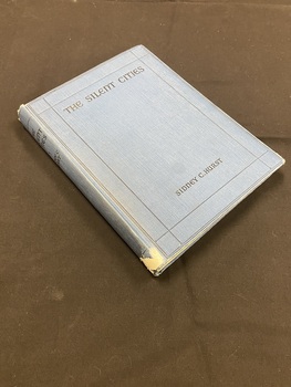 Blue hardcover book. Title and author in black print across the spine. Torn white sticker label at the base of the spine. The front cover has a double border of thin black lines, inside the border the title is printed across the top and the author at the bottom.