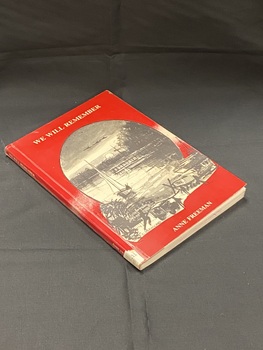 Red paperback book with white sticker taped to bottom of spine with DDC number on it. The front cover has the title printed at the top and author at the bottom. In the centre there is a large oval with a black and white sketched image of a sailboat on the water near a jetty, in the sky is the setting sun and three flying aircraft. Below the oval the drawing continues of soldiers, a medical jeep, ship and an aircraft on the ground.