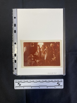 Colour photo of nurses in uniform and patients on stretchers in a room.