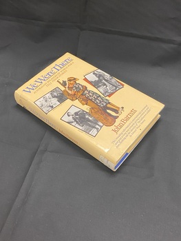 Cream coloured dust-jacket, title in blue along the spine. Cover shows an image of a soldier and a woman embracing, surrounded by three black and white photographs. Title is printed at the top and author at the bottom. There is a white spine label at the base of the spine.
