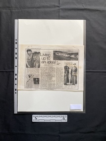 A photocopy of a newspaper clipping that includes a title, captions, three columns of text and four black and white photos