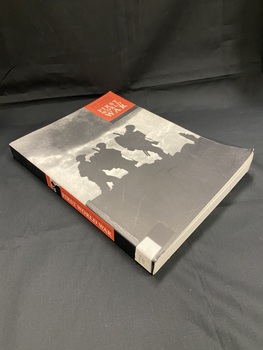 Paperback cover with black spine. The spine contains a red panel with title details and a silhouette of a soldier. The front cover is a black and white image of the silhouettes of three soldiers, there is a red panel in the top right corner showing the title and author.