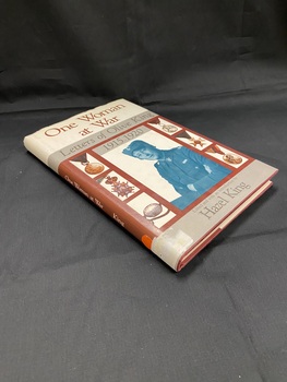 Hardcover book with dust jacket. The cover has a cream panel across the top with the title in brown print. Below this is a grey panel with the subtitle. Below that is a large brown panel displaying a black and white photo of Olive King, on either side of the photo are three smaller images of various medals (six in total). There is a thin grey panel across the bottom with the editor's name.