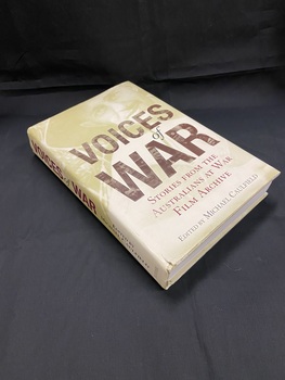 Hard-cover book with dust-jacket. The image on the dustjacket is pale green and wraps around both front and back covers and spine, it shows the face of a soldier and of men walking across a wooden pathway across mud and water. The title is printed across the middle of the front cover in lettering made up of black and white photos of a variety of faces.