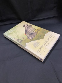 Cover design wraps around the spine and both covers. Lower section is a pale yellow/white colour with silver text. The higher section is a torn green image of a grassed field and tree with black and white images of a lady and pram, a young boy, and a man in a wheelchair with one red poppy.