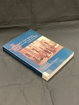 Dark green paperback with spine label taped to base of spine. Title printed in white down the spine. Front cover has title and series information printed in white, overlaying an Australian Air Force emblem. In the centre of the front cover is a sepia photograph image of 13 men in long coats standing out the front of a large stone building.