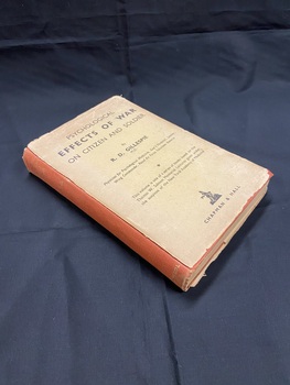 Faded red cloth-bound book with an extremely worn and torn dust-jacket that has its spine missing. Title printed in gold on the cloth-bound spine. What's left of the dust-jacket is faded light brown with black print.