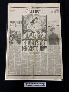Large format pages cut from newspaper.  Front page has large headlines with images of soldiers and medals and eight columns of text, all in black and white.
