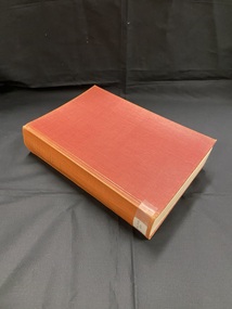 Worn, red hard-cover book. Title printed in gold across the spine. Spine label taped to base of spine.