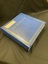 Three ring binder, royal blue, photograph album. Five sets of three horizontal gold lines spaced out down the spine. Triple gold line border around the front cover with the word photographs printed in gold across the cover. Large number of plastic covered, white self-adhesive pages inside.