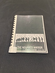 Spiral bound paperback booklet with a black plastic spine and a clear plastic protective sheet over the cover. The cover is black with a white rectangle template at the bottom of the page. Inside the template is a drawn black and white image of a line of silhouettes of wounded soldiers and the title printed below in white.