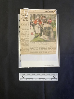 Folded A5 booklet printed on white paper, consisting of pictures and text. Text outlines the order of ceremony.  Newspaper clipping consists of a title, caption, four columns of text and a colour photo.