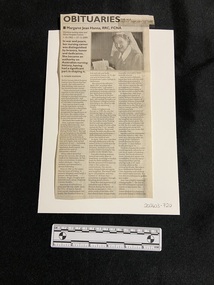 Newspaper clipping with heading typed in bold at the top and three columns of text. At the top of the first column is one paragraph in bold type. At the top of the other two columns is a photo of a woman holding a document, wearing a nurses uniform.