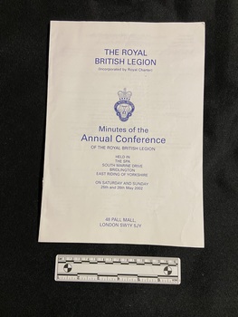 Staple bound booklet on white paper with blue print. The front cover displays the conference details and in the centre is the emblem for the Royal British Legion.