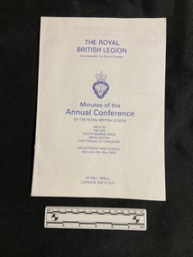 Staple bound booklet on white paper with blue print. The front cover displays the conference details and in the centre is the emblem for the Royal British Legion.