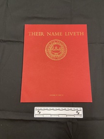 Red paperback book with thin spine. Front cover has the title printed across the top in gold, beneath is a circular emblem of the Imperial War Graves Commission.