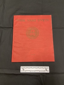 Red paperback book with thin spine. Front cover has the title printed across the top in gold, beneath is a circular emblem of the Imperial War Graves Commission.