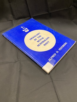 Royal blue cover, white printed title along the spine, white spine label taped to the base. Front cover displays a large white circle in the middle with the title printed inside in royal blue text matching the cover. Author's name printed in white text at the bottom and a white image of an anchor at the top.