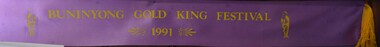 Purple sash with printed gold writing used in the 1991 Buninyong Gold King Festival.
