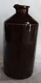 Dark brown glazed cylindrical bottle with pouring lip. Stopper missing. 