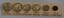 Seven pre-decimal coins fixed wo a labelled card. 