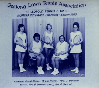 Group of tennis players holding racquets.