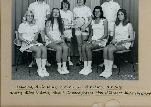 Group of tennis players holding racquets.