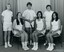 Group of tennis players holding racquets.