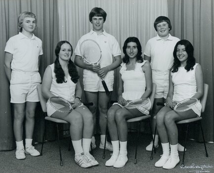 Group of tennis players holding racquets.