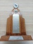 Wooden trophy with golden disc at top and crossed tennis racquets below