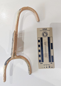Iron hook with a wall plate painted in cream.