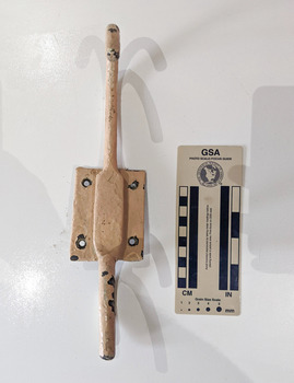 Iron hook with a wall plate painted in cream.