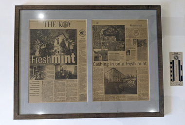 Two pages from newspaper article mounted in a frame.
