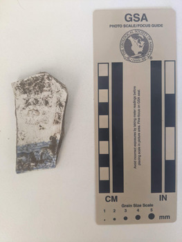 Ceramic shard with white glaze finish and a blue decorative design. 