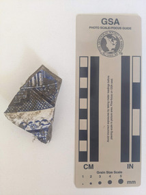 Ceramic shard with white glaze and blue decorative pattern
