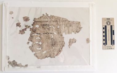 Weathered fragments of paper with black text 