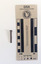 Corroded nail with a rectangular shaft that narrows to a blunt tip.