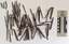 Collection of corroded nails with a rectangular head and square shaft that narrows to a blunt tip.