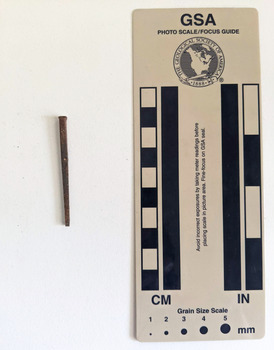 Corroded nail with a small rectangular head.